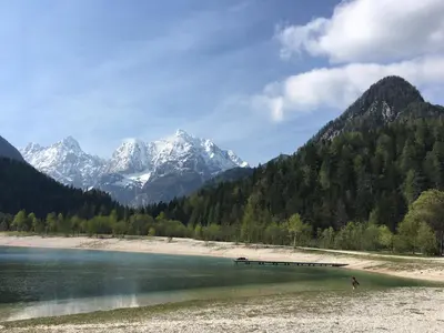a lake with snow capped mountains in the background at Apartments ViTa in Kranjska Gora
