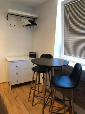 a small table and two stools in a room at Castle View Studio in Ljubljana