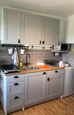 a kitchen with white cabinets and a sink at Castle View Studio in Ljubljana