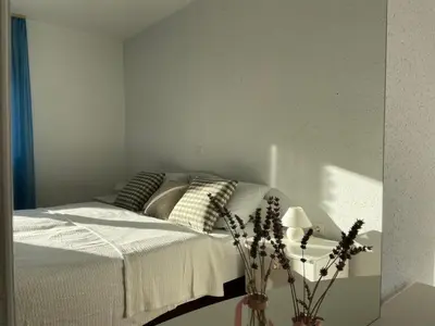 a bedroom with a bed and a vase with flowers at Beautiful house surrounded by pure nature in Rogašovci