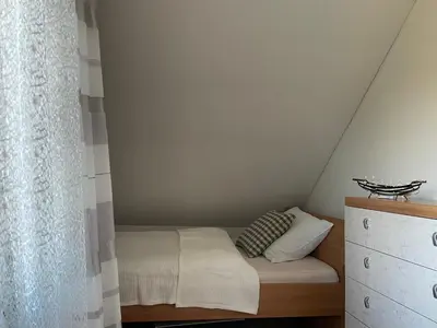 a small bedroom with a bed in a attic at Beautiful house surrounded by pure nature in Rogašovci