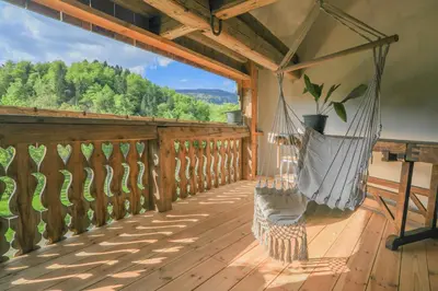 a porch with a hammock on a wooden deck at Apartment Krnicar in Zgornje Gorje