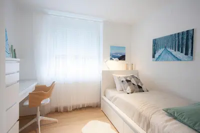 a bedroom with a bed and a desk and a window at Apartment Galerija Bled in Bled