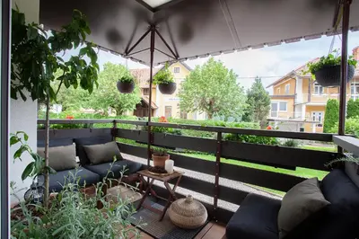 a balcony with blue couches and an umbrella at Apartment Galerija Bled in Bled