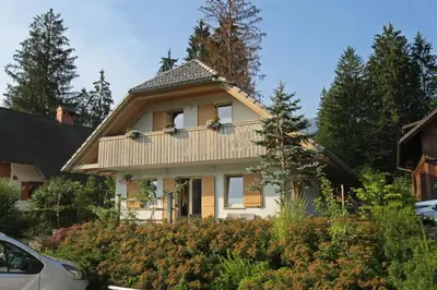 a white house with a gambrel roof at Apartma LODI BOHINJ Za dve,štiri, šest, ali osem oseb in Bohinj