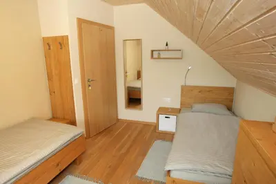 a small bedroom with two beds and a mirror at Apartma LODI BOHINJ Za dve,štiri, šest, ali osem oseb in Bohinj