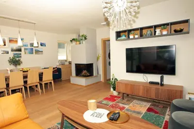 a living room with a large television and a dining room at Apartma LODI BOHINJ Za dve,štiri, šest, ali osem oseb in Bohinj