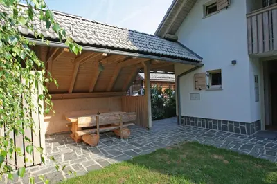 a wooden patio with a wooden bench under a roof at Apartma LODI BOHINJ Za dve,štiri, šest, ali osem oseb in Bohinj