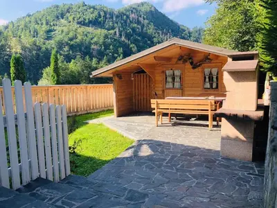 a wooden cabin with a picnic table and a fence at Apartma Eržen in Zgornje Gorje