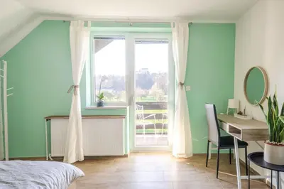 a bedroom with a bed and a desk and a window at Deerwood Villa-Modern cozy 2br apartment with castle view in Bled