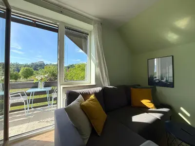 a living room with a couch and a large window at Deerwood Villa-Modern cozy 2br apartment with castle view in Bled