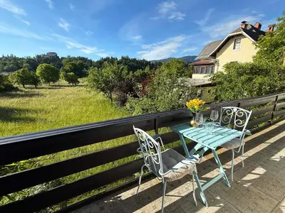 a table and chairs on the balcony of a house at Deerwood Villa-Modern cozy 2br apartment with castle view in Bled