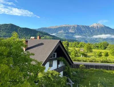 a house with a mountain in the background at Deerwood Villa-Modern cozy 2br apartment with castle view in Bled