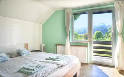 a bedroom with a bed and a large window at Deerwood Villa-Modern cozy 2br apartment with castle view in Bled