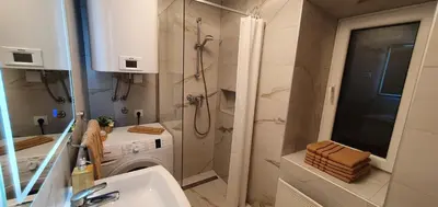 a bathroom with a sink and a washing machine at Počitniška hiša Taler in Bohinj