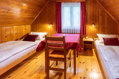 a room with two beds and a chair in it at Počitniška hiša Taler in Bohinj