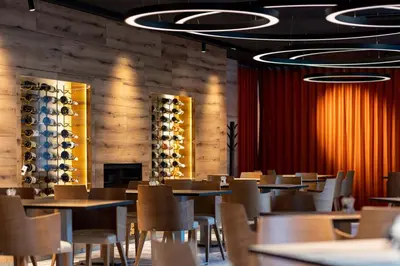 a dining room with tables and chairs and wine racks at Hotel A plus in Celje