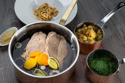 a pot with meat and vegetables on a table at Hotel A plus in Celje