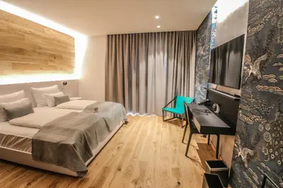 a bedroom with a bed and a desk and a television at Hotel A plus in Celje