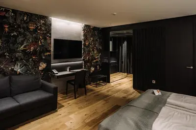 a bedroom with a bed and a desk and a couch at Hotel A plus in Celje