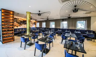 a dining room with tables and blue chairs at Hotel A plus in Celje