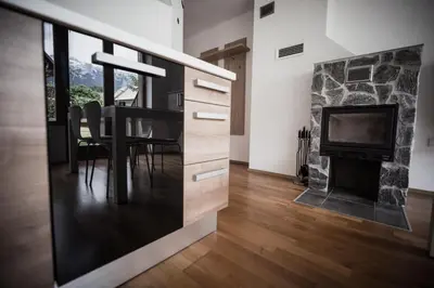 a dining room with a table and a fireplace at APARTMENT ALPIN BOVEC in Bovec