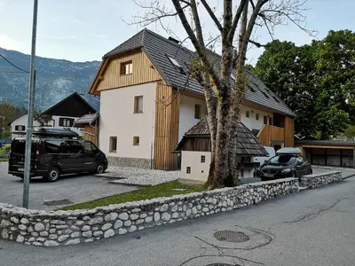 a house with two cars parked in front of it at APARTMENT ALPIN BOVEC in Bovec
