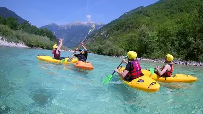 three people in kayaks in the water on a river at APARTMENT ALPIN BOVEC in Bovec