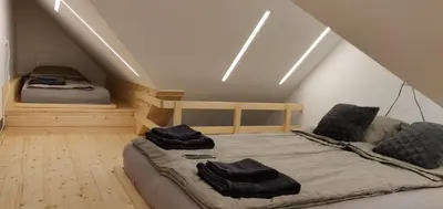 a room with a bed and two beds in a attic at Vila Mojca - Studio 13 in Kranjska Gora