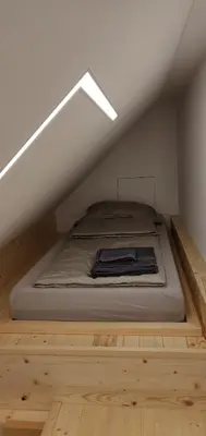 a bed in the attic of a room at Vila Mojca - Studio 13 in Kranjska Gora