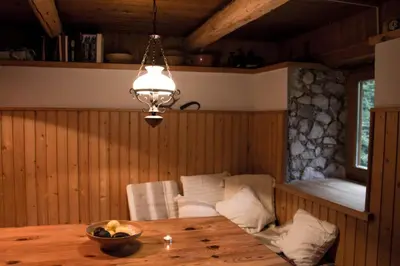 a dining room with a table and a chandelier at Cottage Trenta in Bovec