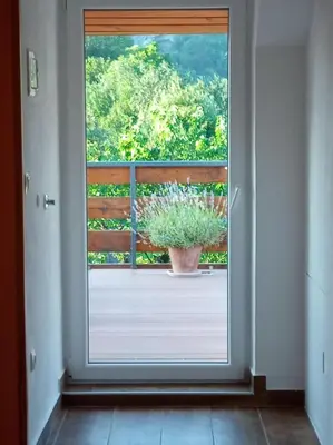 a window with a potted plant on a balcony at Tree in Bled