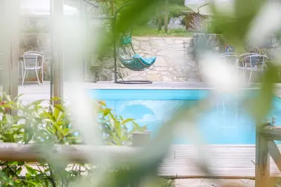 a patio with a hammock and a pool at SOBE Andrejina in Branik