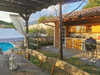 an outdoor kitchen with a table and a grill at SOBE Andrejina in Branik