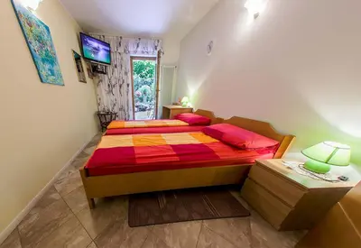 a bedroom with a bed with a colorful comforter at SOBE Andrejina in Branik