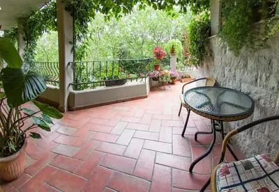 a patio with a table and chairs and plants at SOBE Andrejina in Branik