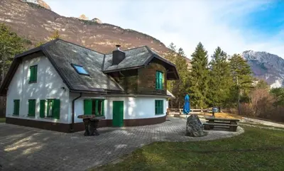 a house with green doors and a mountain at Casa Monte in Bovec