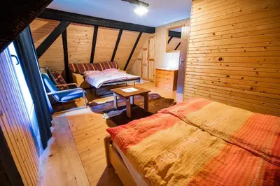 a bedroom with a bed and a couch in a room at Hiska Rutar Valley Voje in Studor v Bohinju