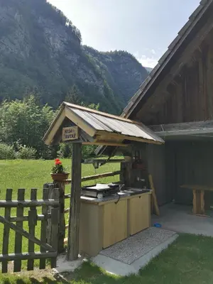 a barbecue grill with a sign on it next to a fence at Hiska Rutar Valley Voje in Studor v Bohinju