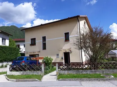 a house with a blue car parked in front of it at Apartma Rutar in Tolmin