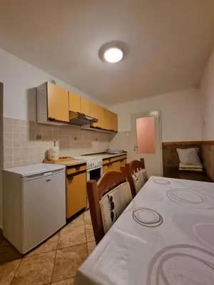 a kitchen with a table and a kitchen with yellow appliances at Apartma Rutar in Tolmin