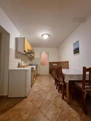 a kitchen with a table and chairs and a kitchen with a table and a counter at Apartma Rutar in Tolmin