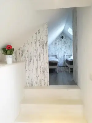 a room with white walls and stairs with a window at Apartment Kokoro in Bogojina