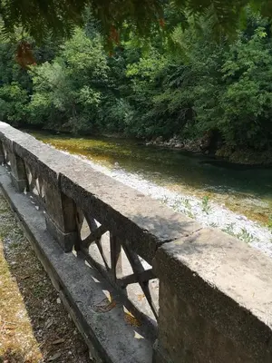 a stone bench sitting next to a river at Apartma Humar in Tolmin