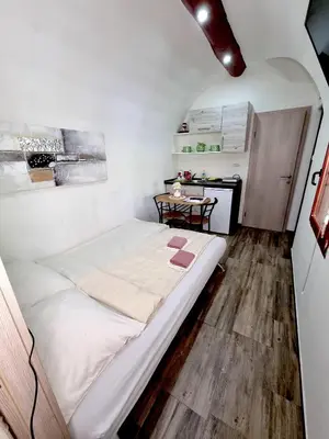 a small bedroom with a large bed and a table at Glamping Rajska vas in Šentjur