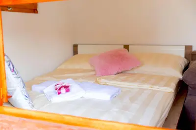a bed with two towels and a pink box on it at Glamping Rajska vas in Šentjur