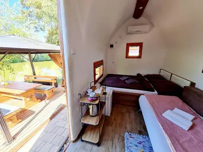 a small bedroom with a bed and a balcony at Glamping Rajska vas in Šentjur