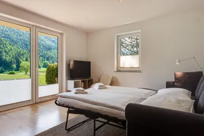 a bedroom with a large bed and a large window at Villa Planina in Rateče