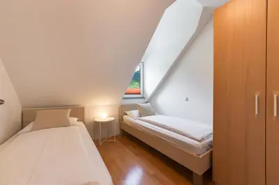 two beds in a small room with a window at Villa Planina in Rateče