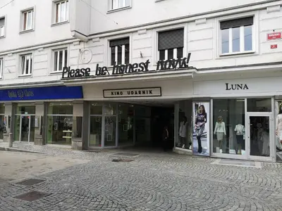 a large white building with a store on a street at Modern studio in the heart of the city in Maribor